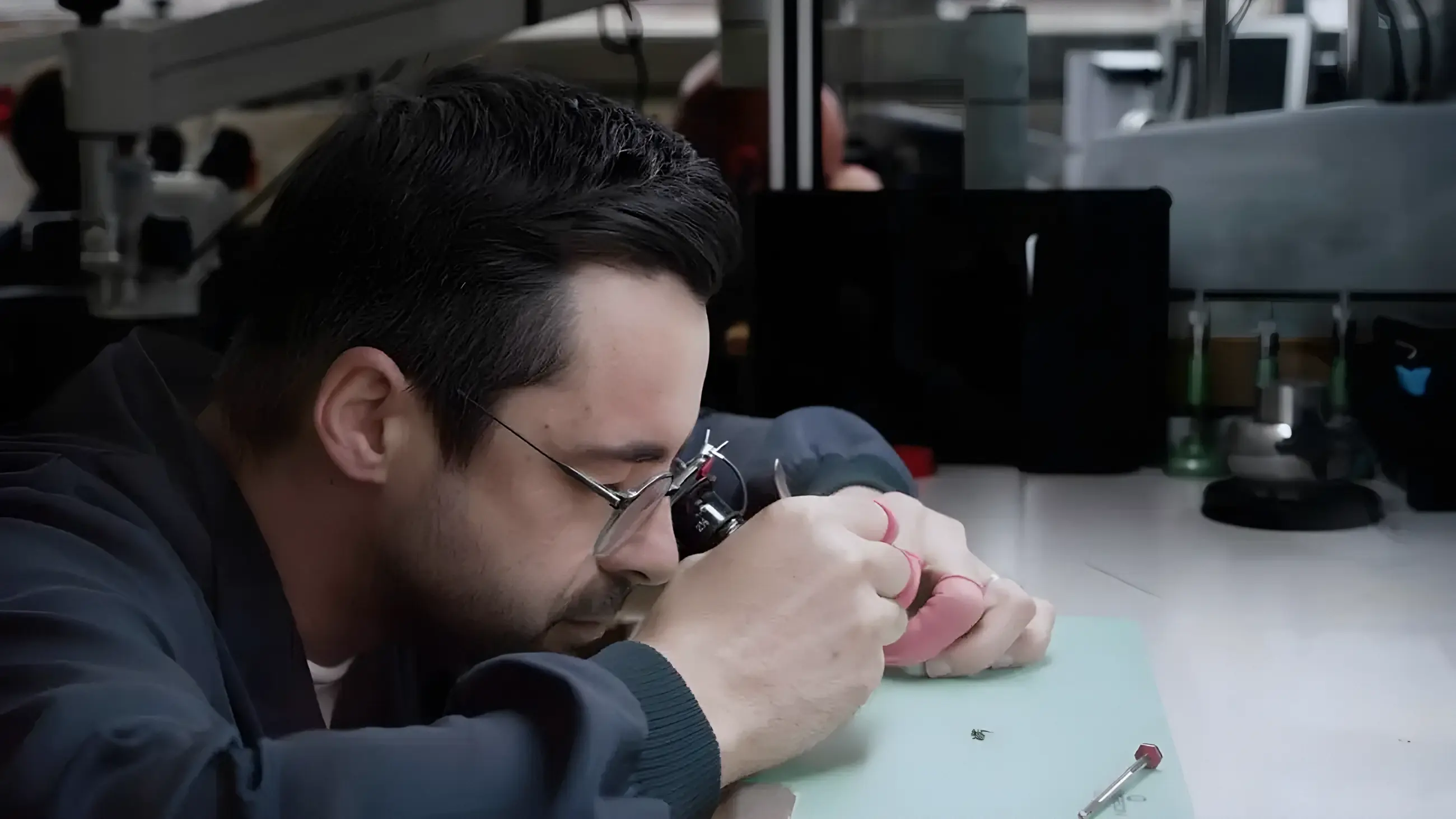 Horloger au travail sous loupe